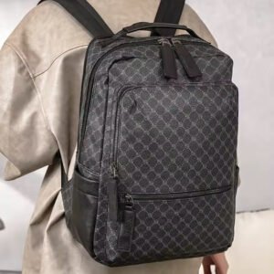 Morral de lujo con estampado geométrico de rombos en tonos grises y negros, detalles de cuero sintético en la base y bolsillos, cierres metálicos y asa superior reforzada.