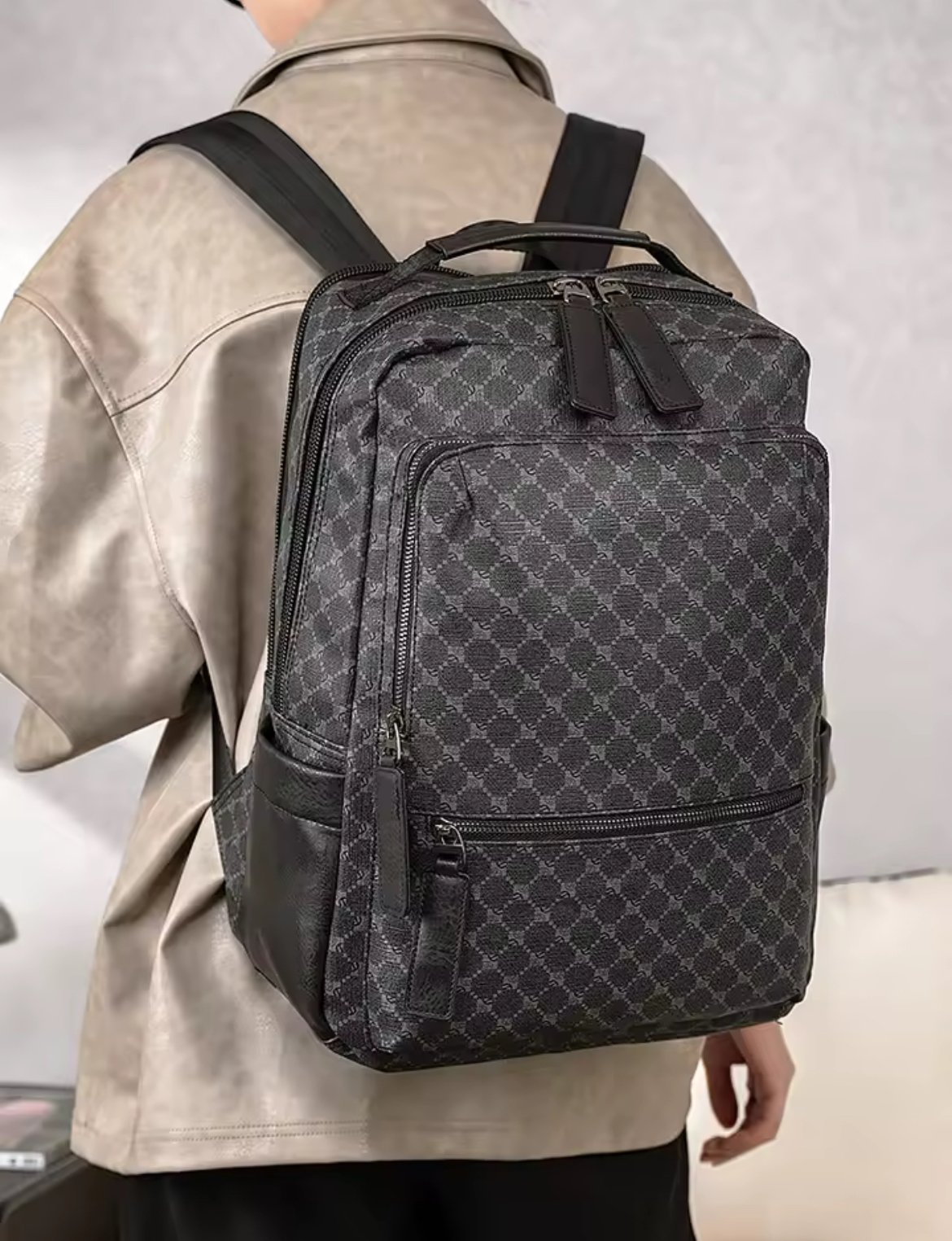 Morral de lujo con estampado geométrico de rombos en tonos grises y negros, detalles de cuero sintético en la base y bolsillos, cierres metálicos y asa superior reforzada.