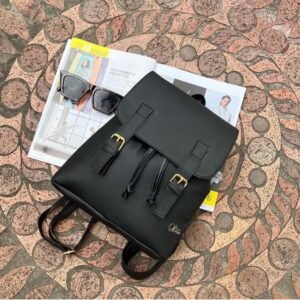 Morral negro de cuero sintético Vivay con textura graneada, detalle de costura vertical roja en el centro, logotipo metálico dorado en la esquina superior y asa superior acolchada.