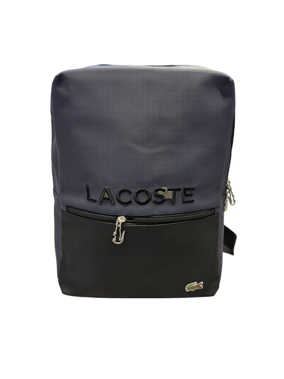 Morral Lacoste en dos tonos, azul marino en la parte superior y negro en la base, con logotipo en relieve, cremallera frontal con tirador de cocodrilo y parche de cocodrilo clásico en la esquina inferior.