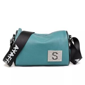 Bolso estilo crossbody con textura granulada, parche frontal de pedrería con letra y correa ancha deportiva con tipografía contrastada.