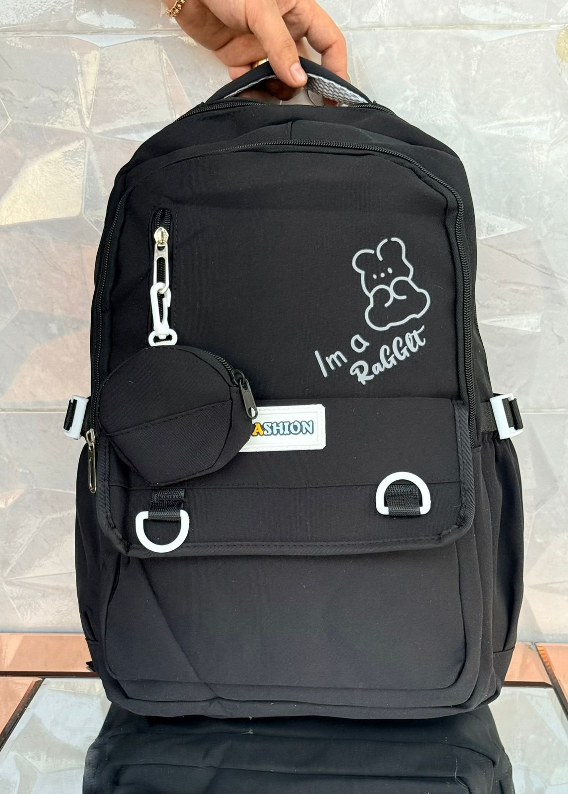 Mochila de estilo coreano con ilustración de personaje y texto 'Im a RABBIT', bolsillo frontal con hebillas, bolsillo vertical con cremallera y estuche circular acoplable.