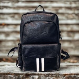 Mochila de piel negra con dos franjas blancas verticales centrales, diseño minimalista y correas ajustables.